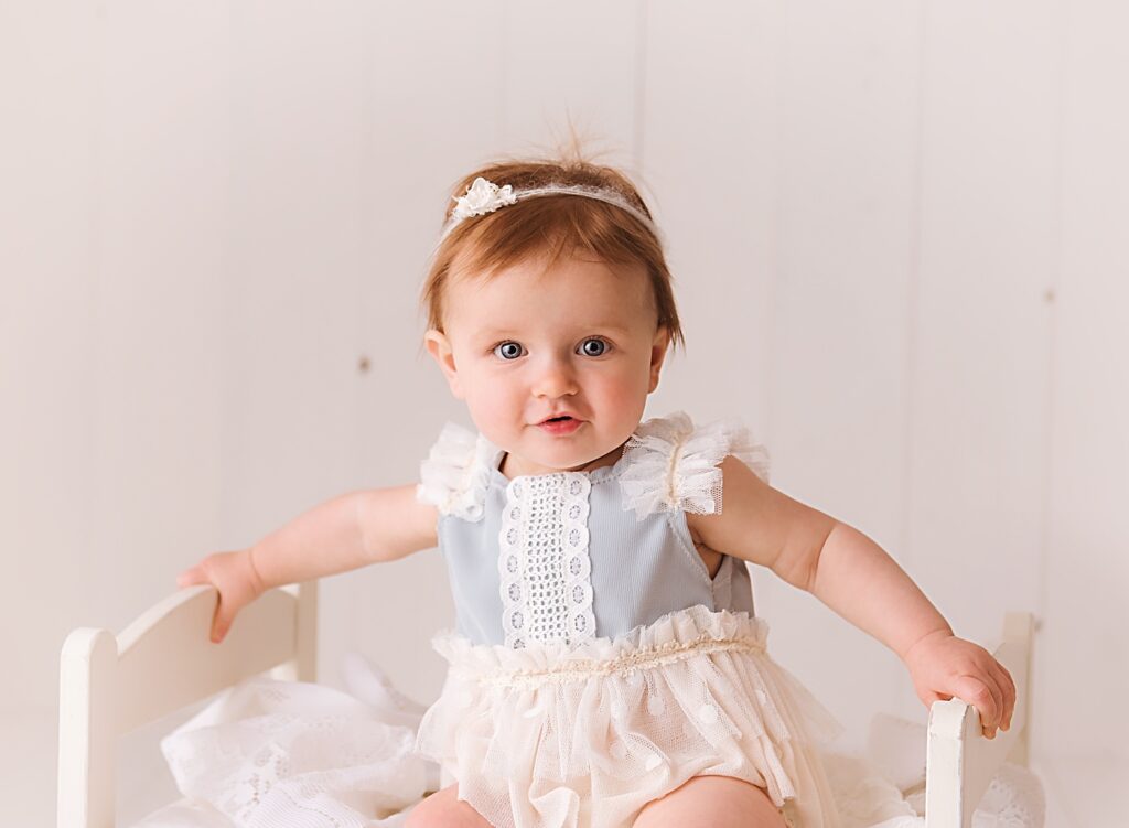 baby sitting on a bed, milestone session